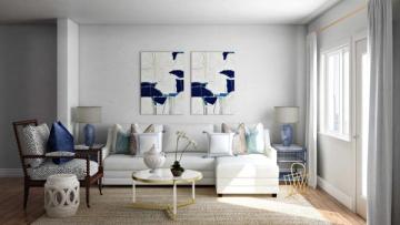 Light-filled traditional living room in soft blues and whites with modern artwork, neutral sofa, and minimalist accessories
