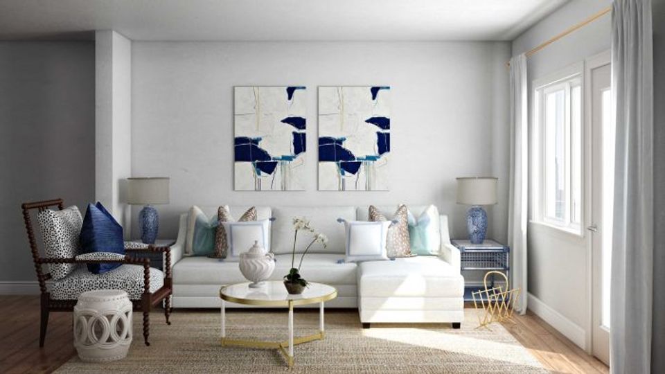 Light-filled traditional living room in soft blues and whites with modern artwork, neutral sofa, and minimalist accessories