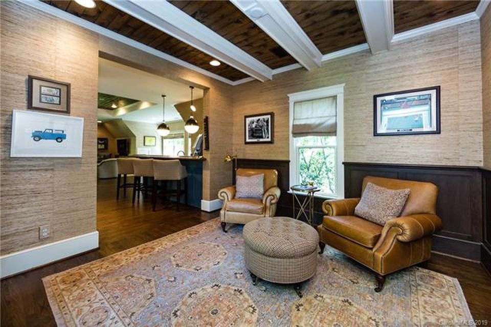 Rustic coastal den with exposed beams, warm leather seating, and earthy tones