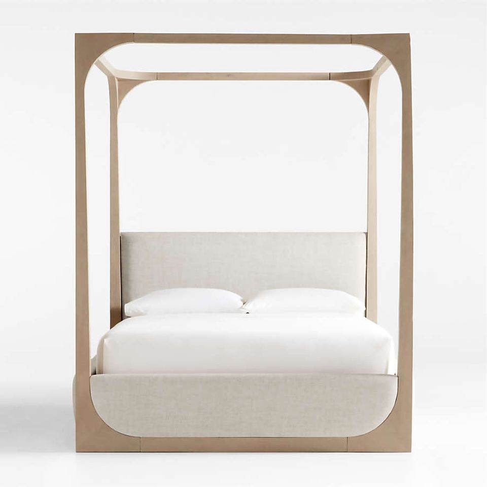 Scandinavian-inspired light wood canopy bed with cream upholstered headboard
