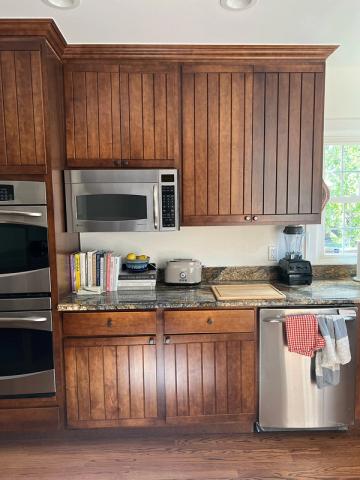 Warm traditional kitchen with rich wood paneling cabinetry and stainless steel appliances