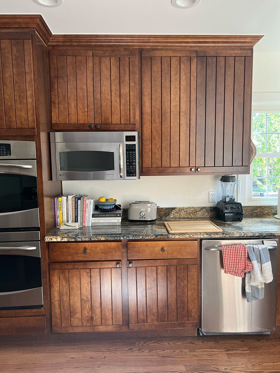 Warm traditional kitchen with rich wood paneling cabinetry and stainless steel appliances