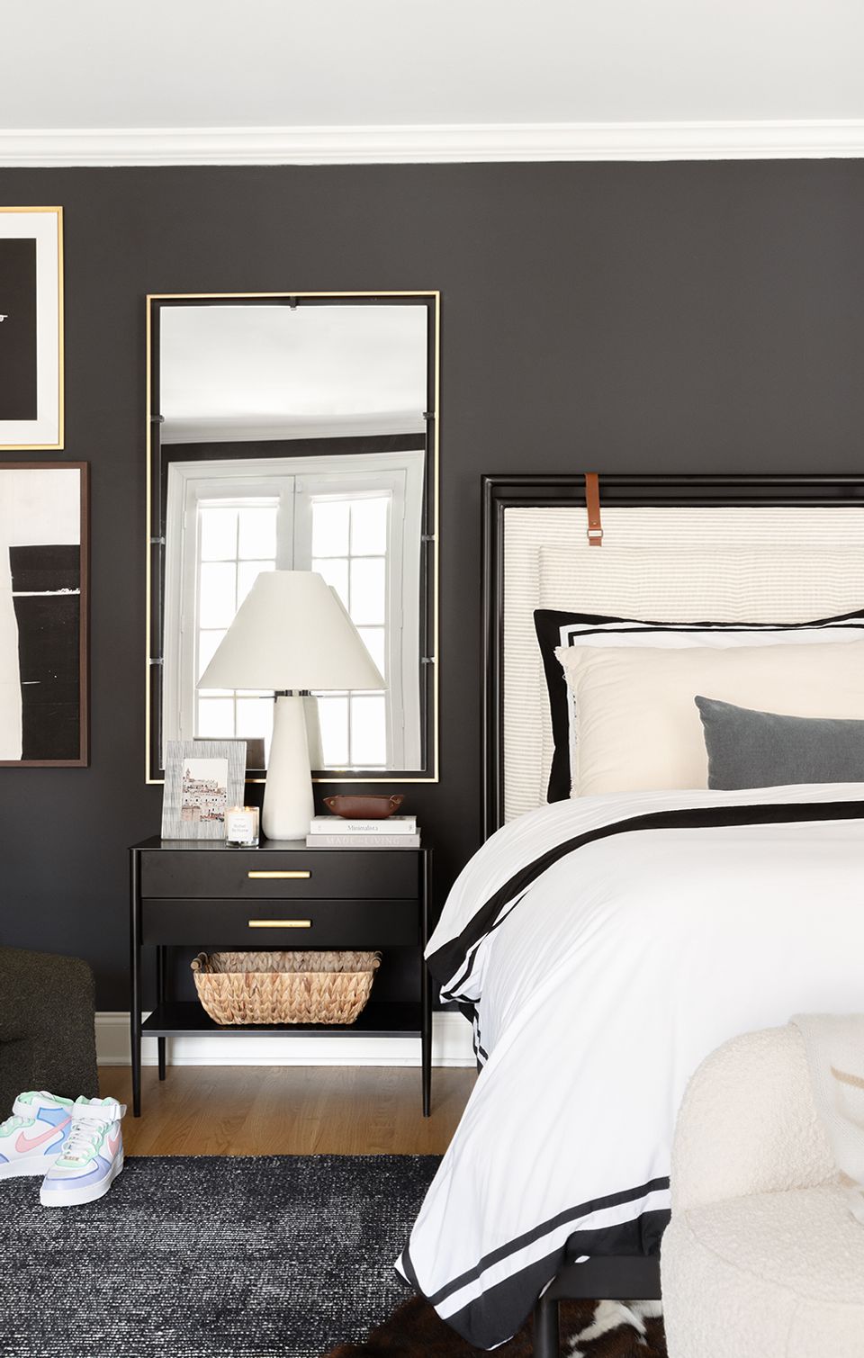 Contemporary bedroom with dark charcoal walls, crisp white bedding, and black metal frame bed