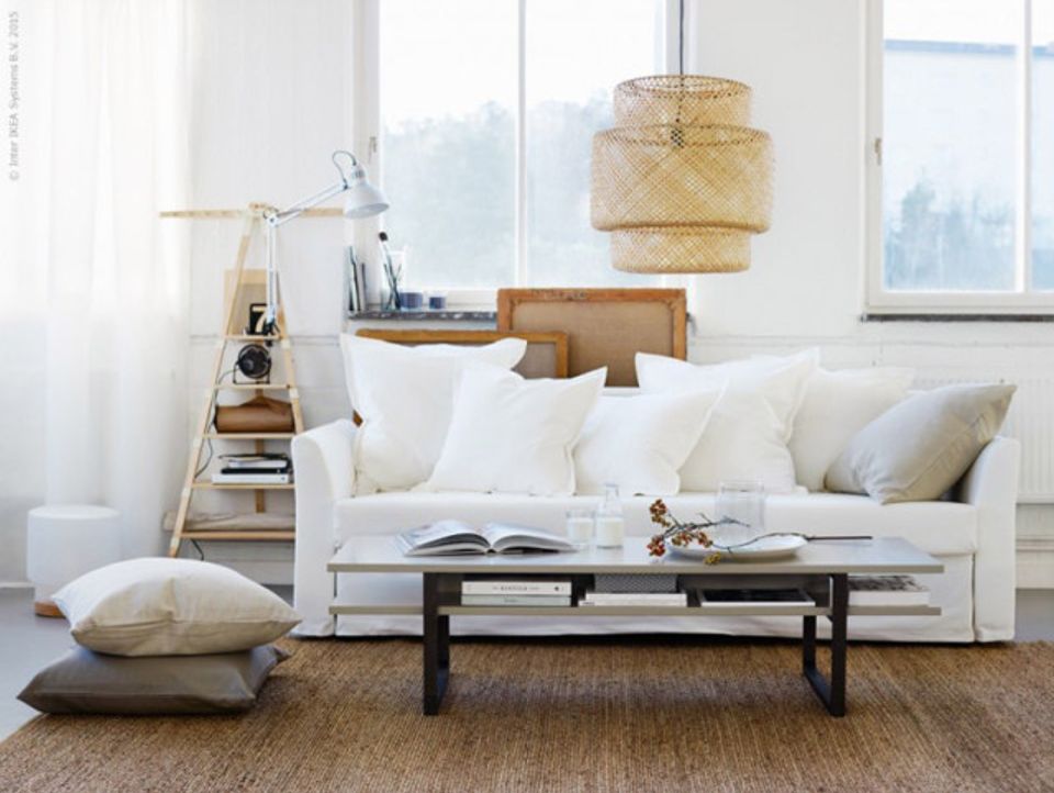 Coastal minimalist living room with cream sofa, woven pendant, and soft neutral palette emphasizing calm