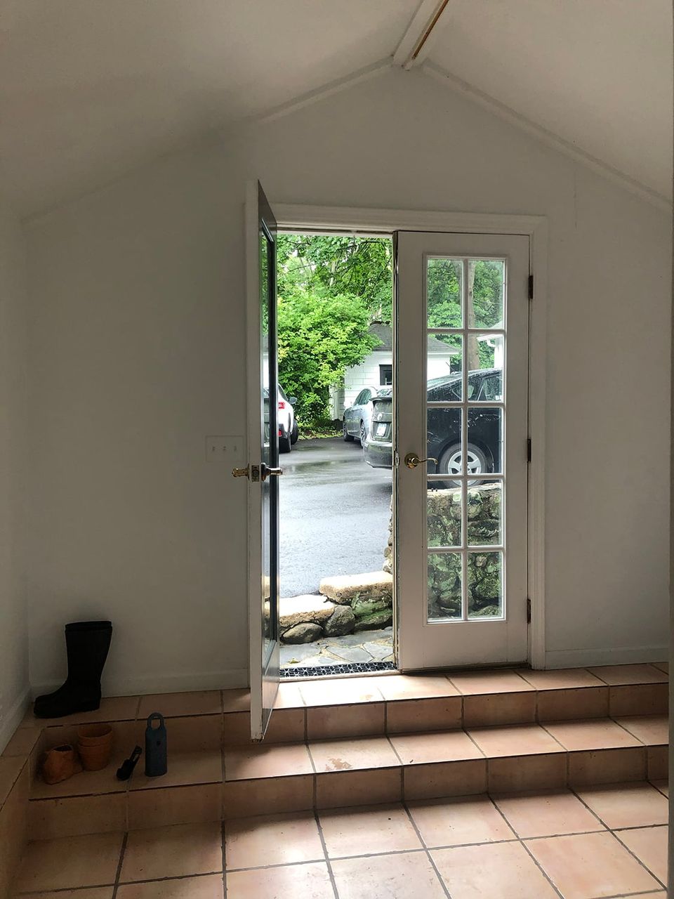 Bright transitional space with terra cotta tile floor and light-filled glass doors