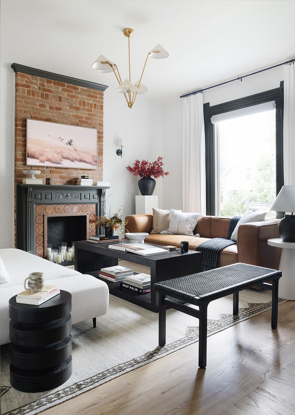 Victorian living room blending exposed brick fireplace, warm tones, and eclectic furnishings