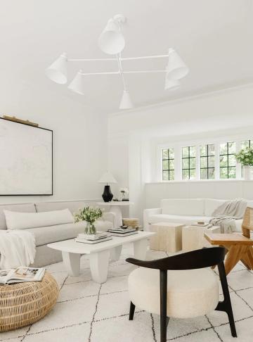 Bright Scandinavian living room in cream and white tones with natural wood accents, clean lines, and minimal wall decor emphasizing airiness and light
