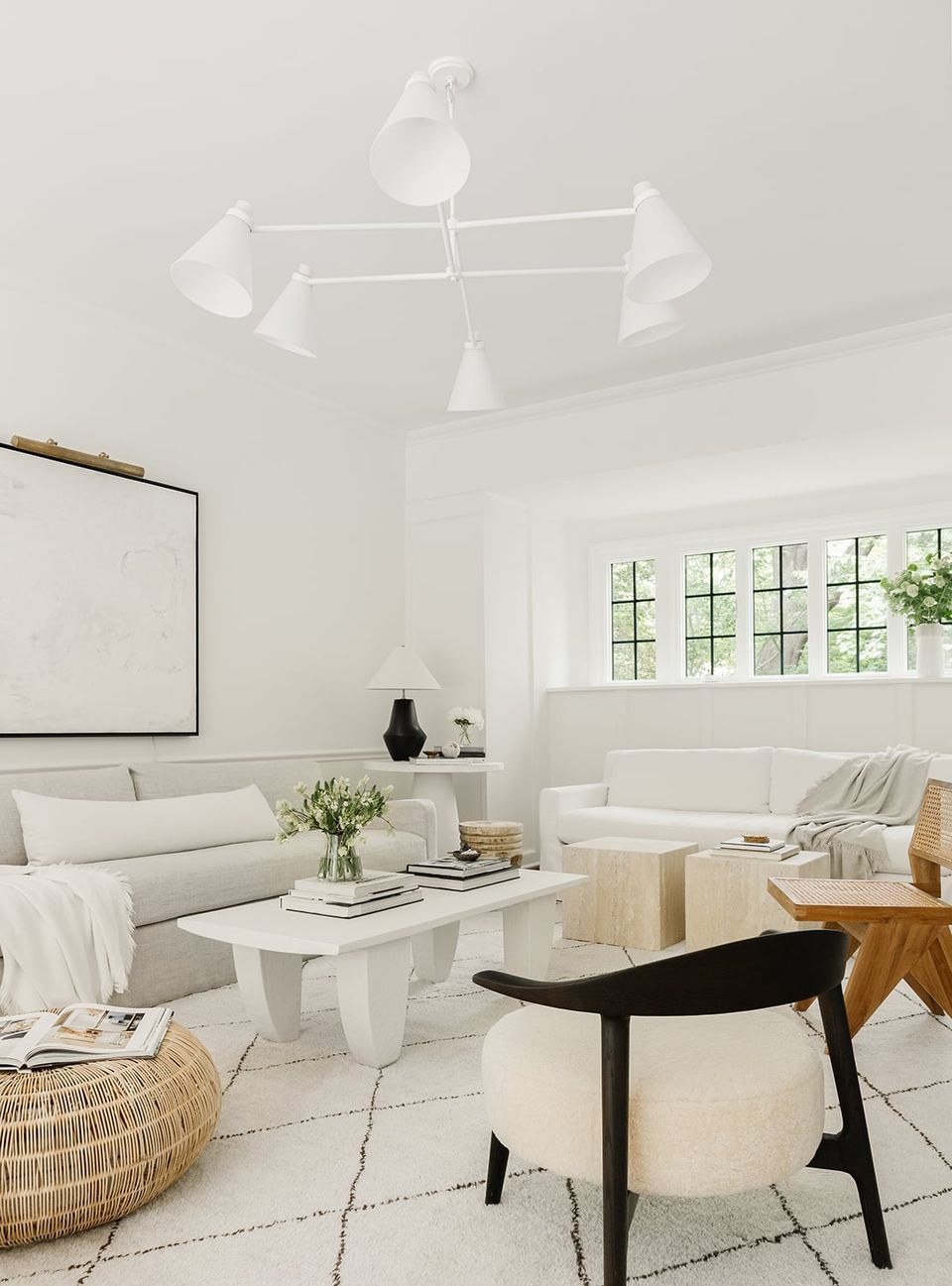 Bright Scandinavian living room in cream and white tones with natural wood accents, clean lines, and minimal wall decor emphasizing airiness and light