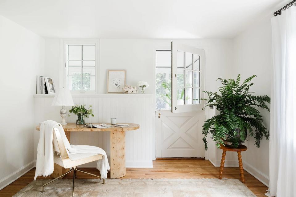 Serene botanical office with warm wood tones, lush greenery, neutral palette, and bright natural light creating a calming, organic atmosphere
