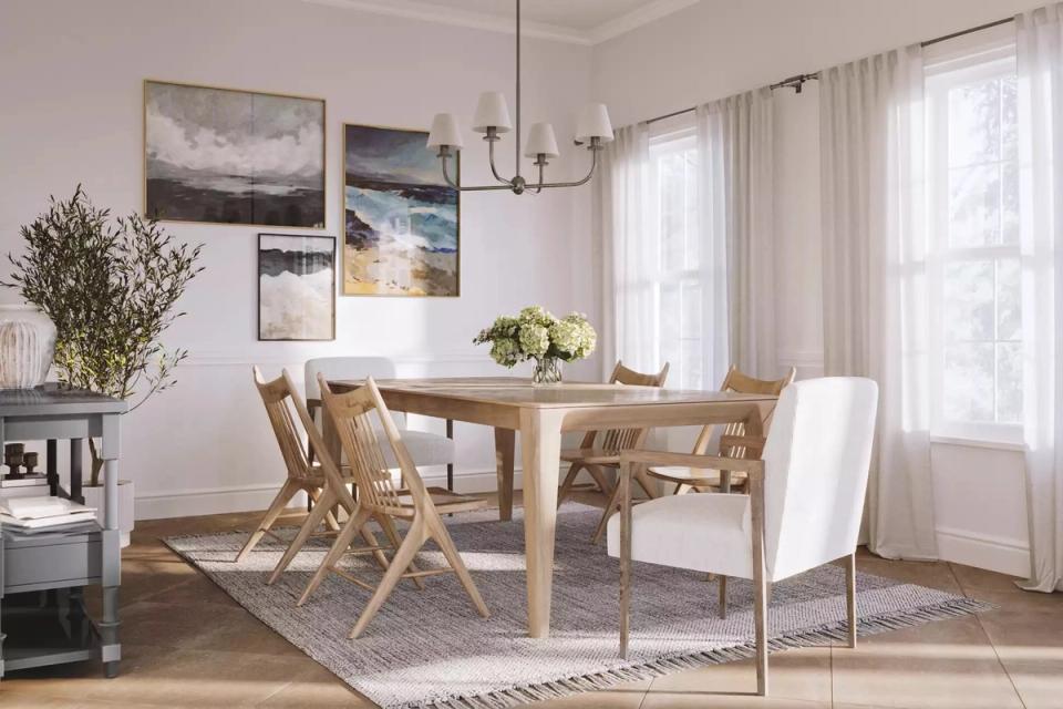 Airy Scandinavian-inspired dining room with light wood table, woven chairs, and gallery wall art