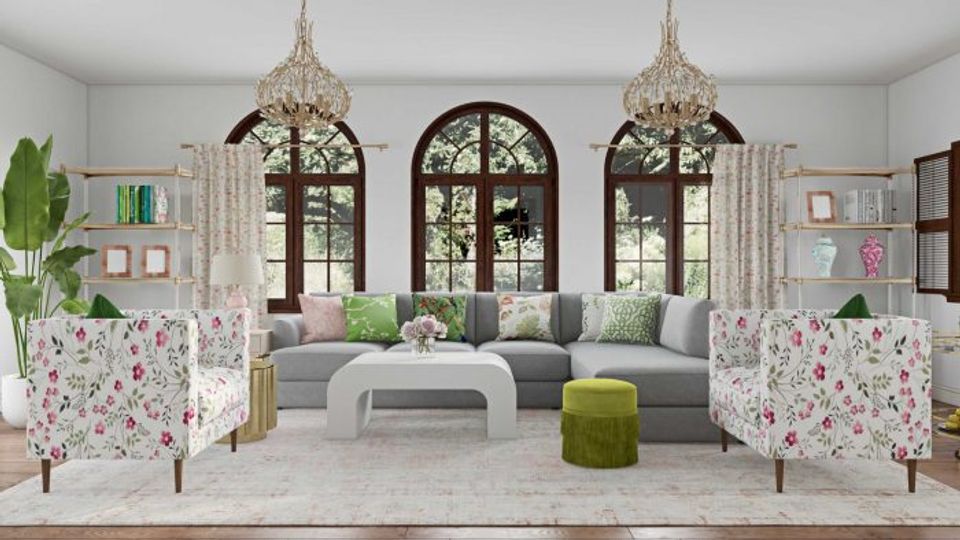 Eclectic traditional space combining floral accent chairs, gray sectional, ornate brass chandeliers, and botanical elements