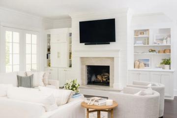 Bright contemporary living room with fireplace surround, built-in shelving, and neutral upholstered seating creating a clean, organized aesthetic