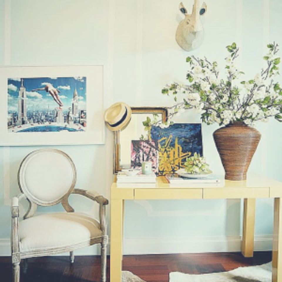 Coastal-inspired desk setup with pale yellow workspace, botanical accents, and breezy blue artwork