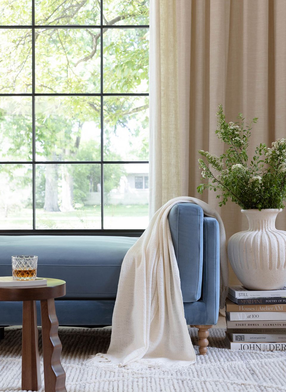 Serene bedroom nook with blue daybed, cream throw, and botanical decor
