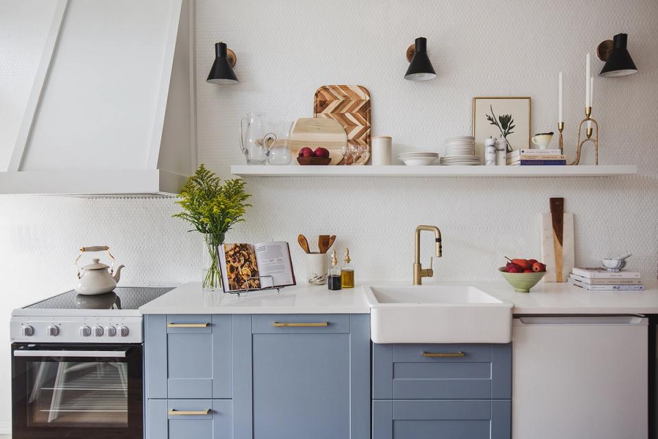 Farmhouse kitchen with soft blue cabinetry, white matte walls, and minimalist open shelving style