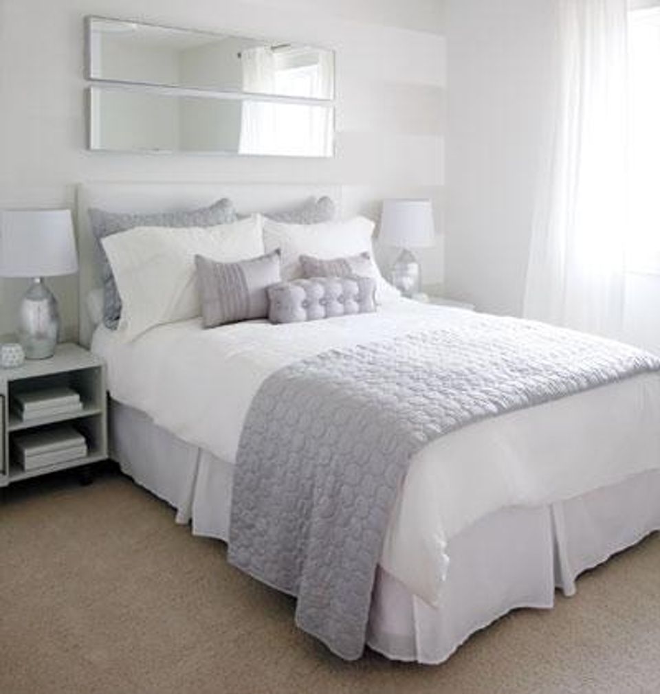 Modern farmhouse bedroom with layered whites, textured accents, and warm beige carpet
