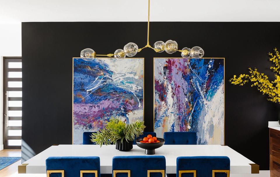 Contemporary dining space with vibrant abstract diptych art and jewel-tone blue velvet seating