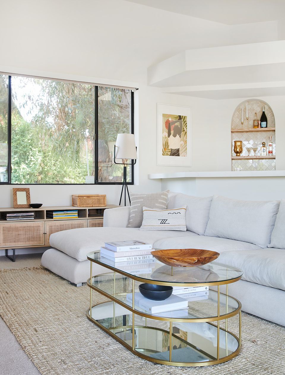 Luxury contemporary space with periwinkle sofa, brass glass table, soft neutrals, and abundant natural light
