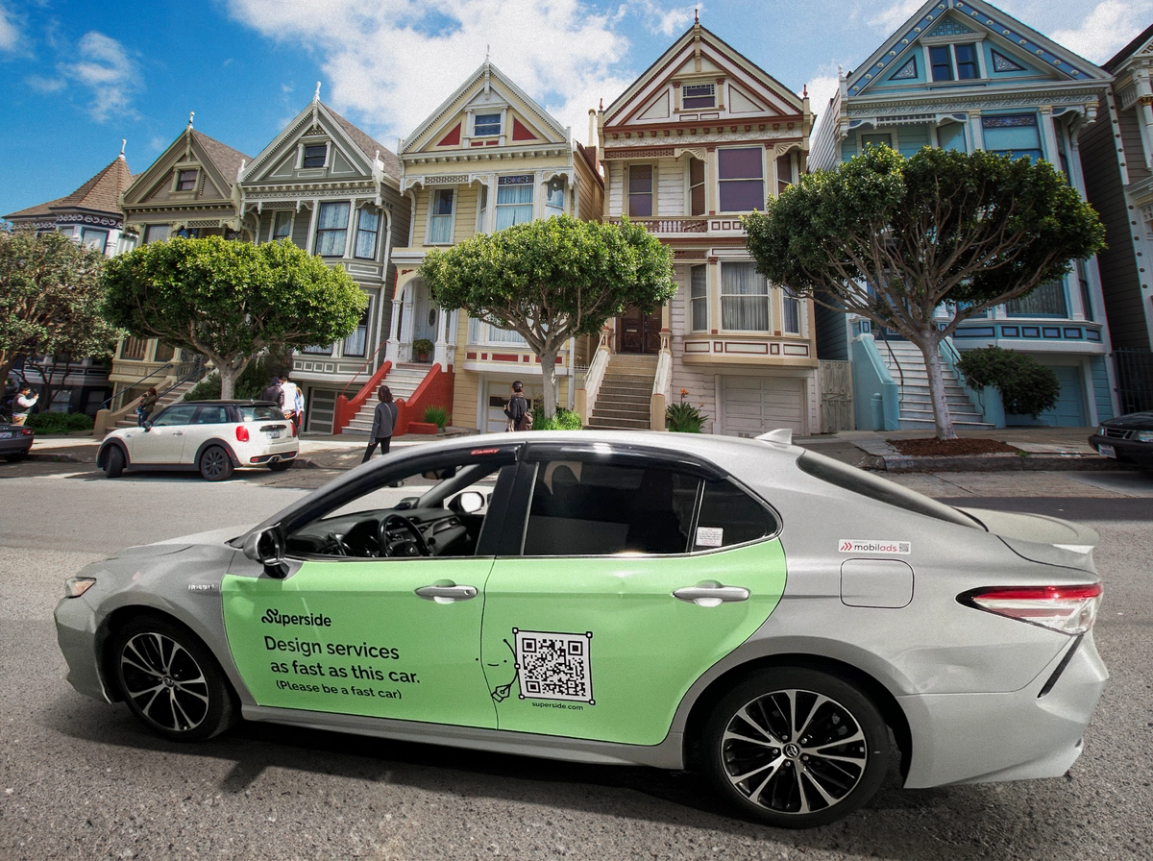 A car wrap advertising Superside on a moving sedan.