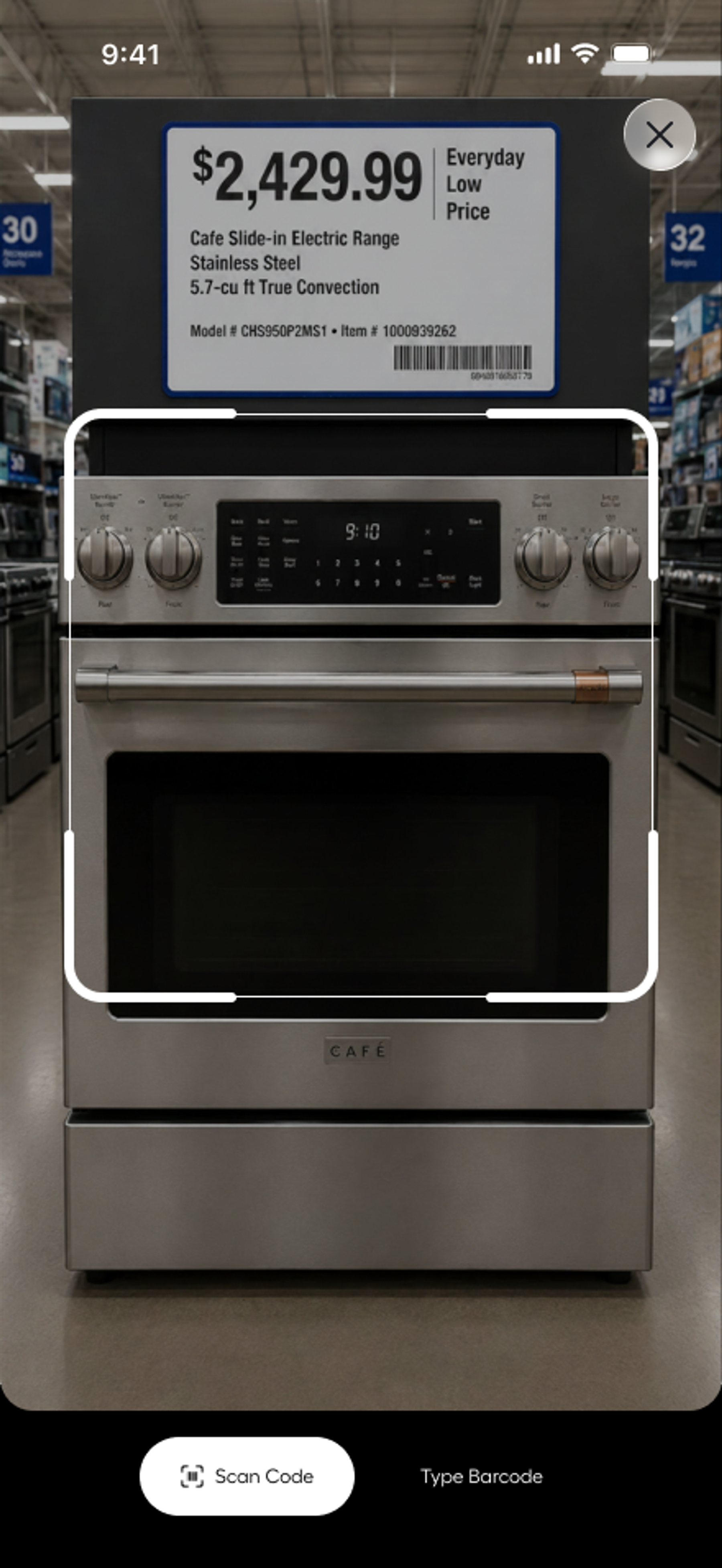 The phone camera in an appliance aisle, framing a stainless range under its price tag, with Scan Code and Type Barcode below.