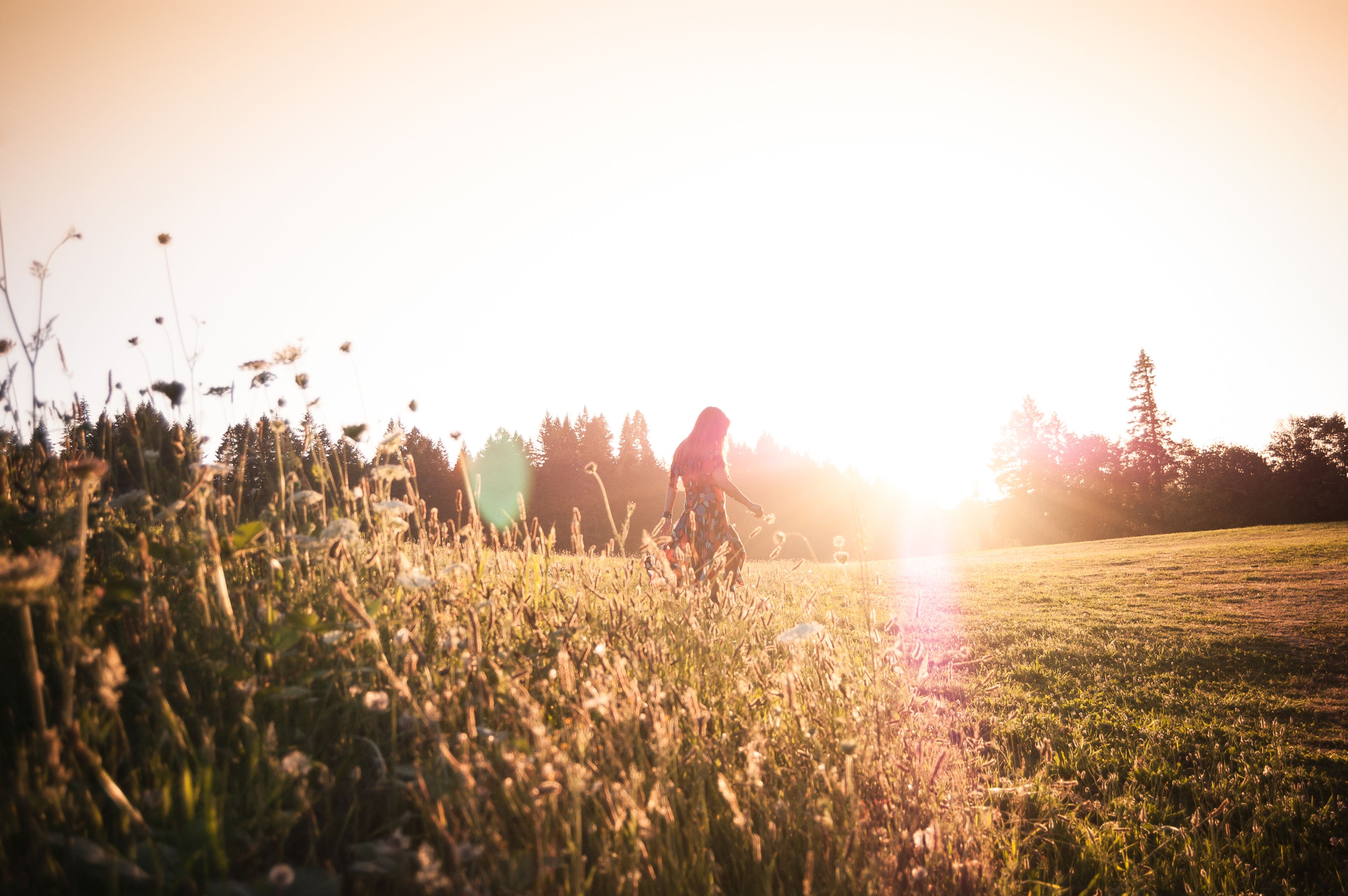 A teen walking in a field at dusk