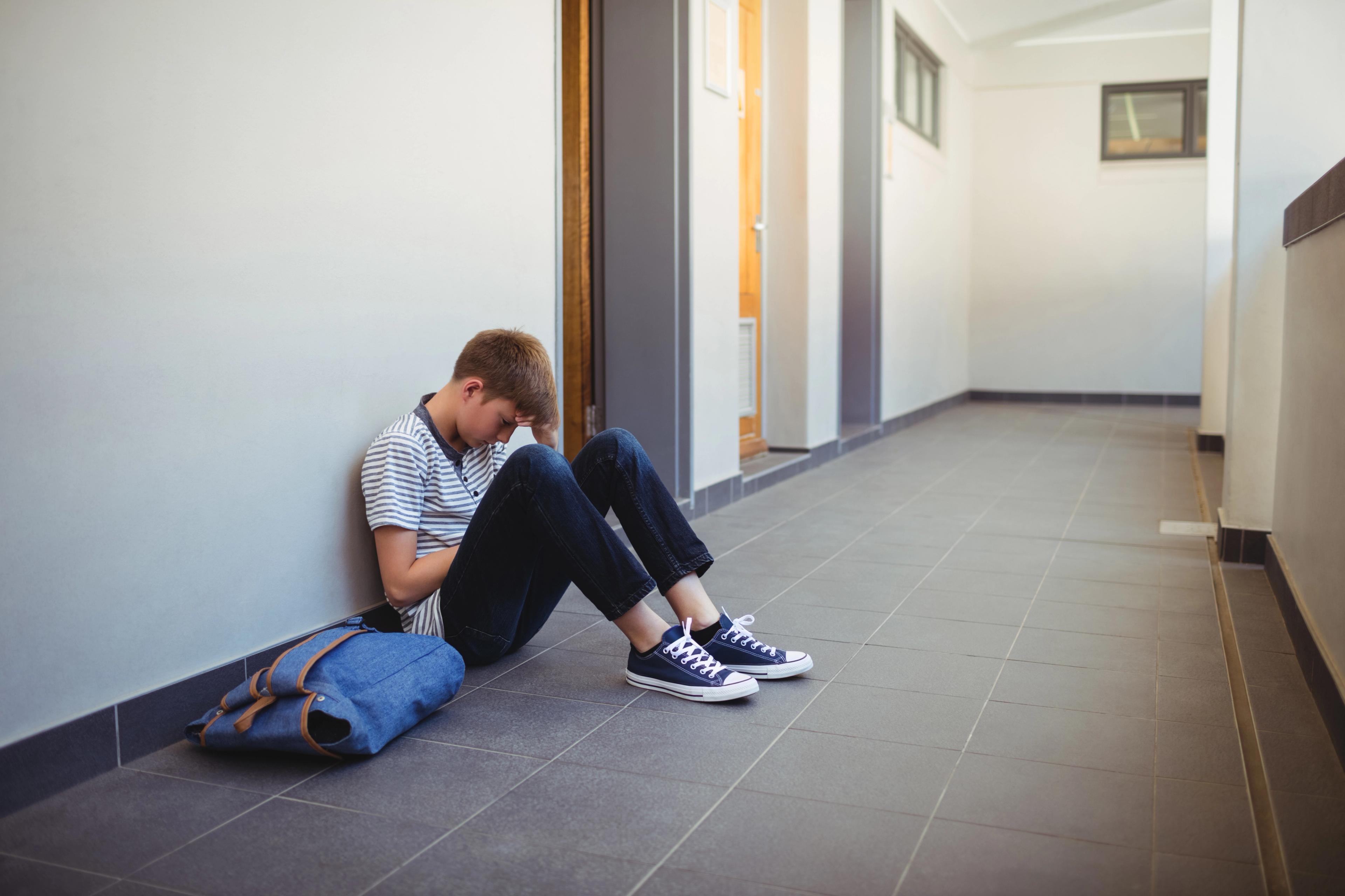 boy sat outside classroom