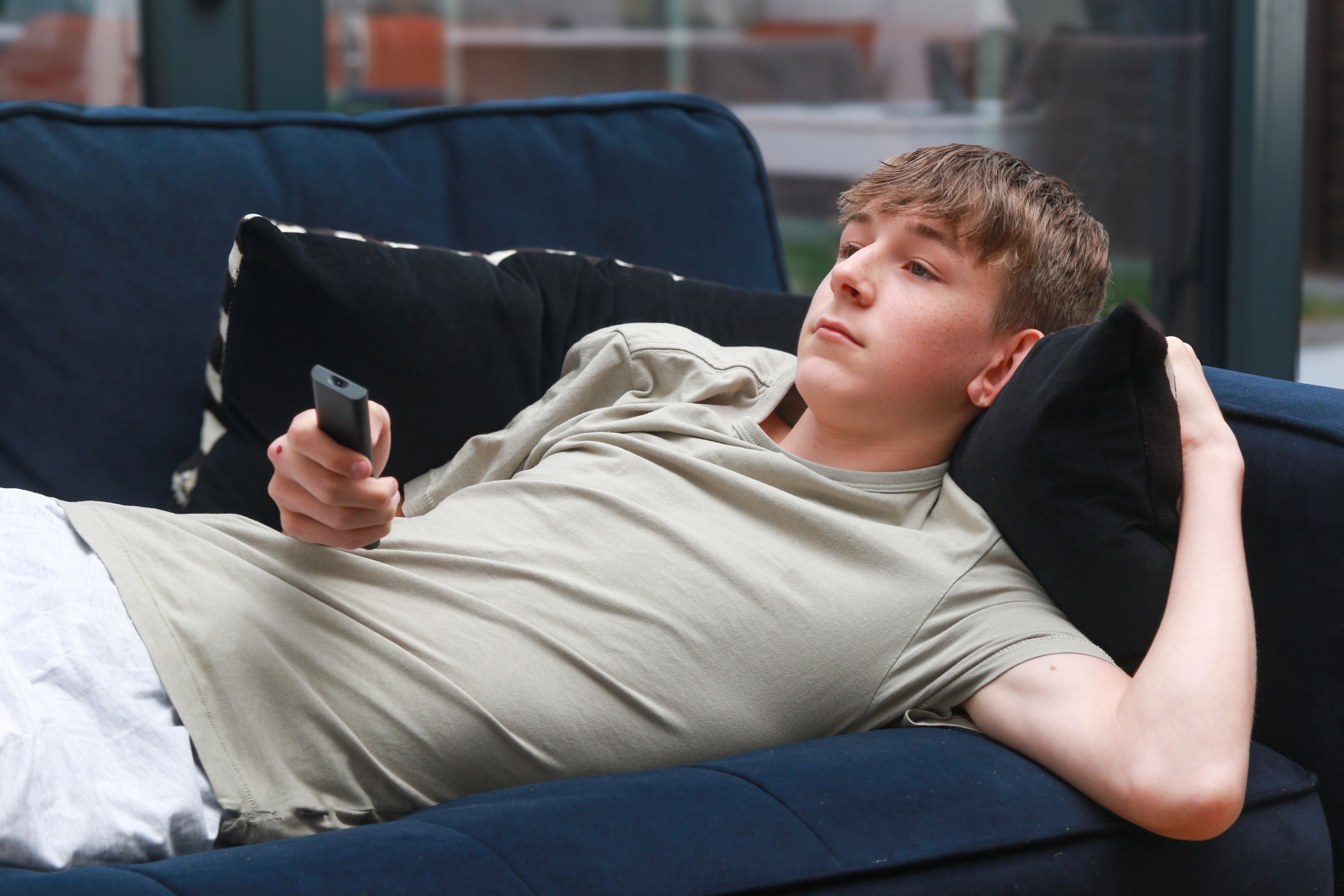 A boy sitting in his bedroom on his phone