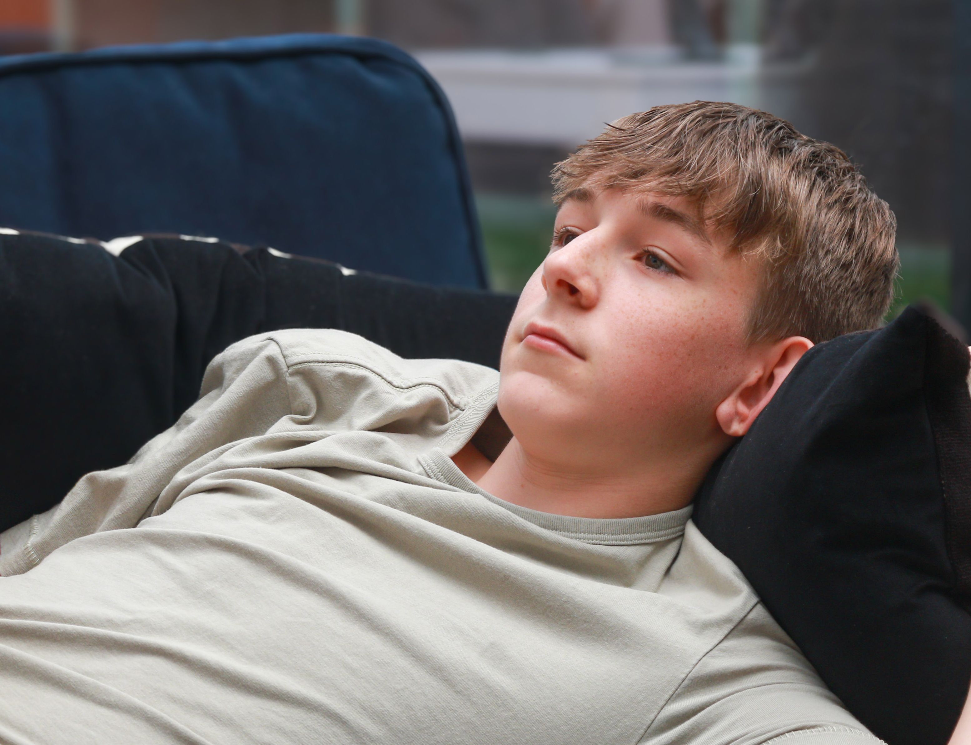 A boy sitting in his bedroom on his phone