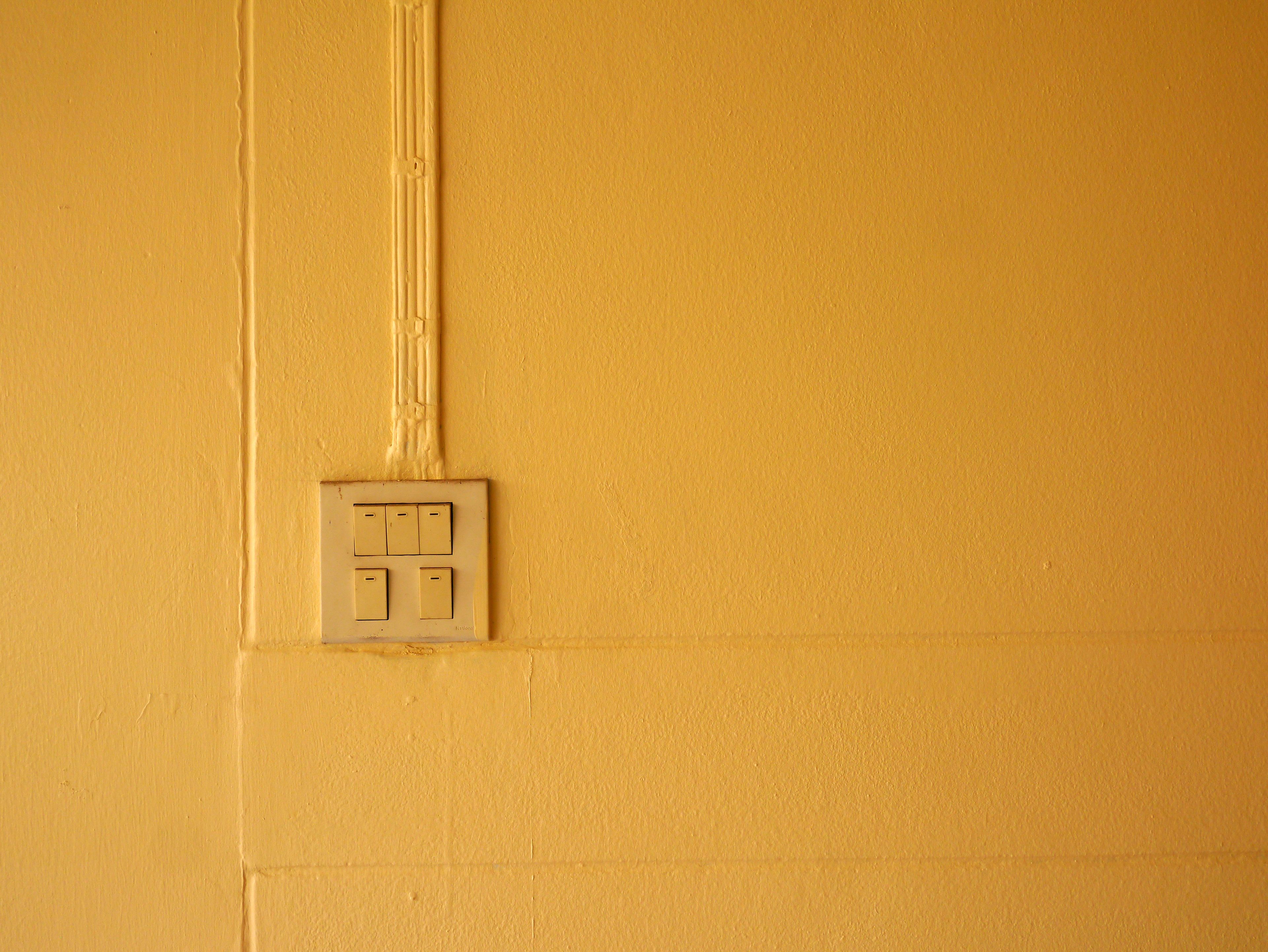 A light switch on a wall where everything is the same colour