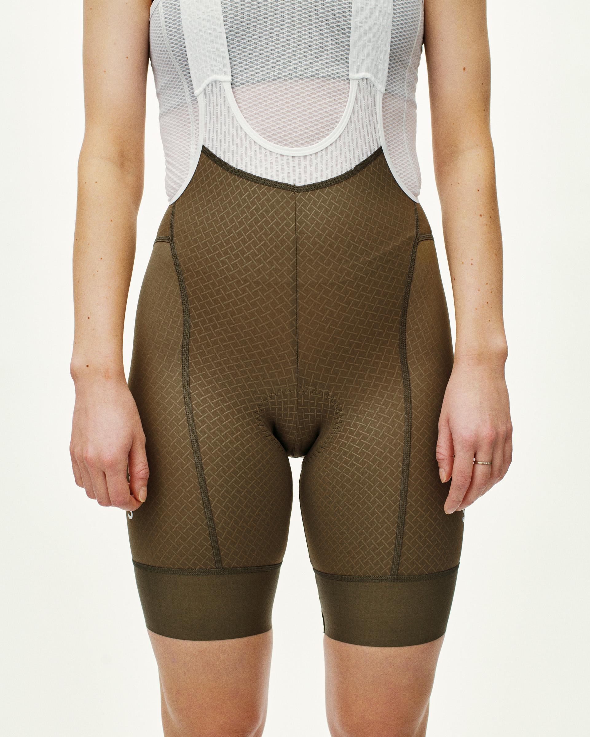 Brown Mechanism cycling bibs on model, front view with textured fabric and white mesh bib straps