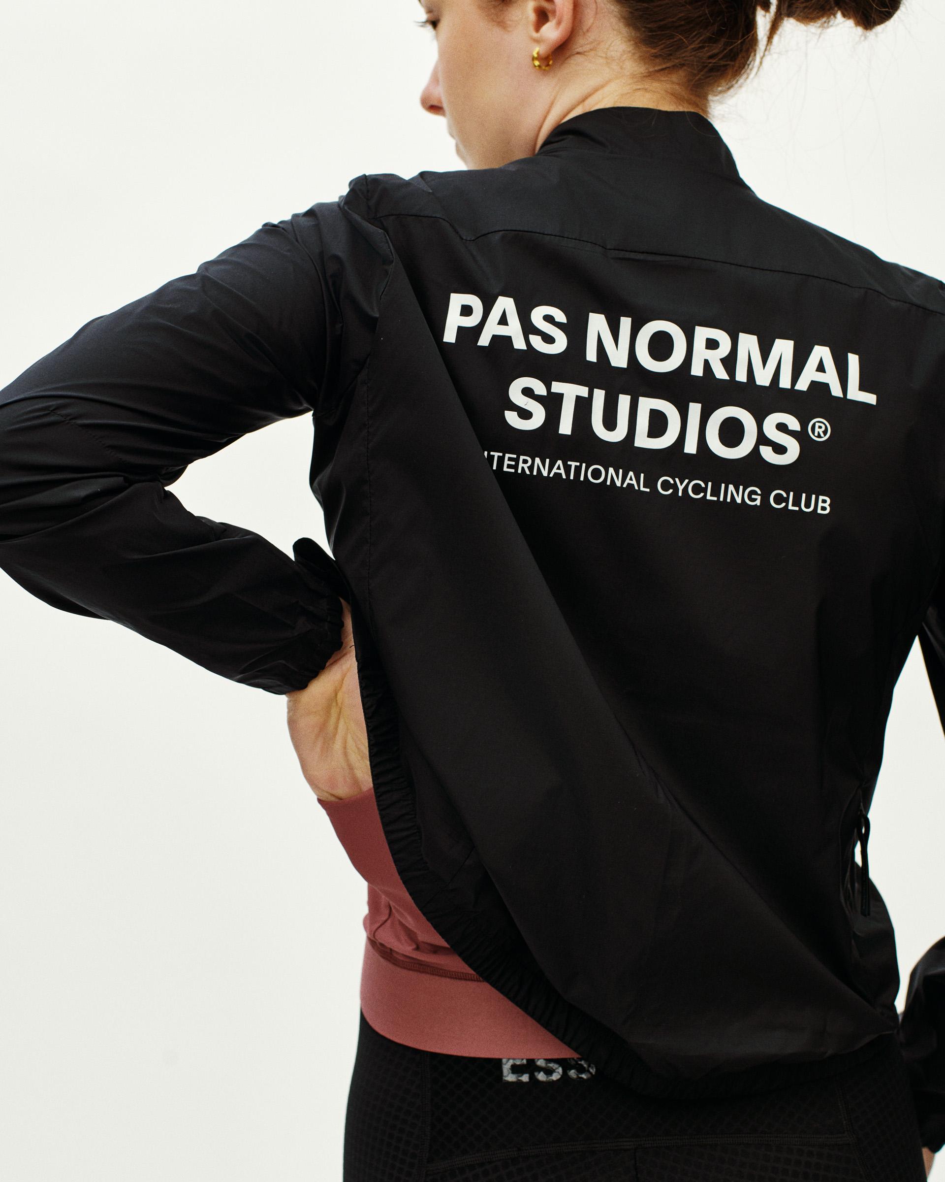 Black Essential Insulated cycling jacket on model, rear view with white brand text