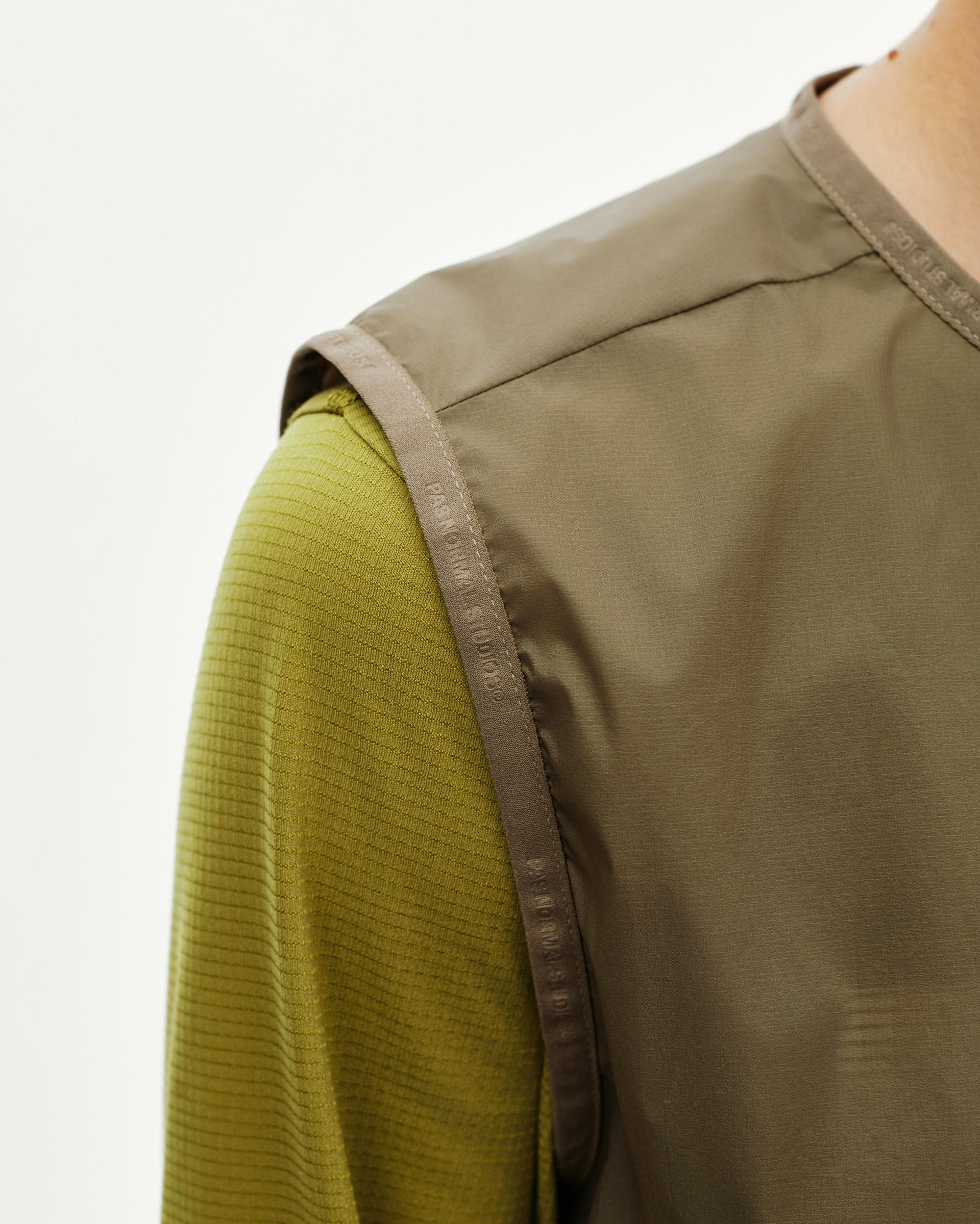 Dusty Earth khaki Balance Windproof cycling vest on model, shoulder detail with branded tape trim