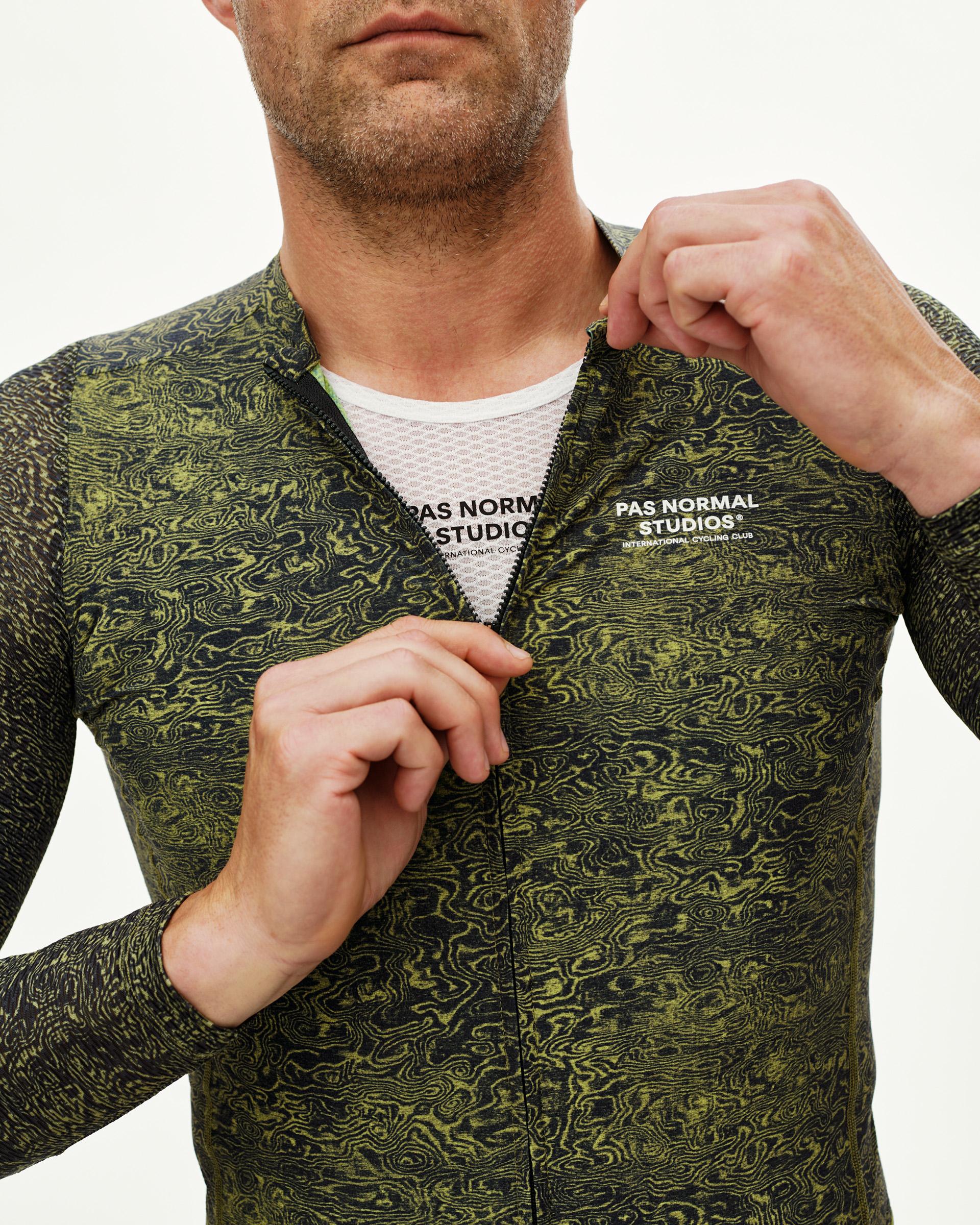 Dark Lime Essential long sleeve cycling jersey, front detail on model with all-over grain print and open zip