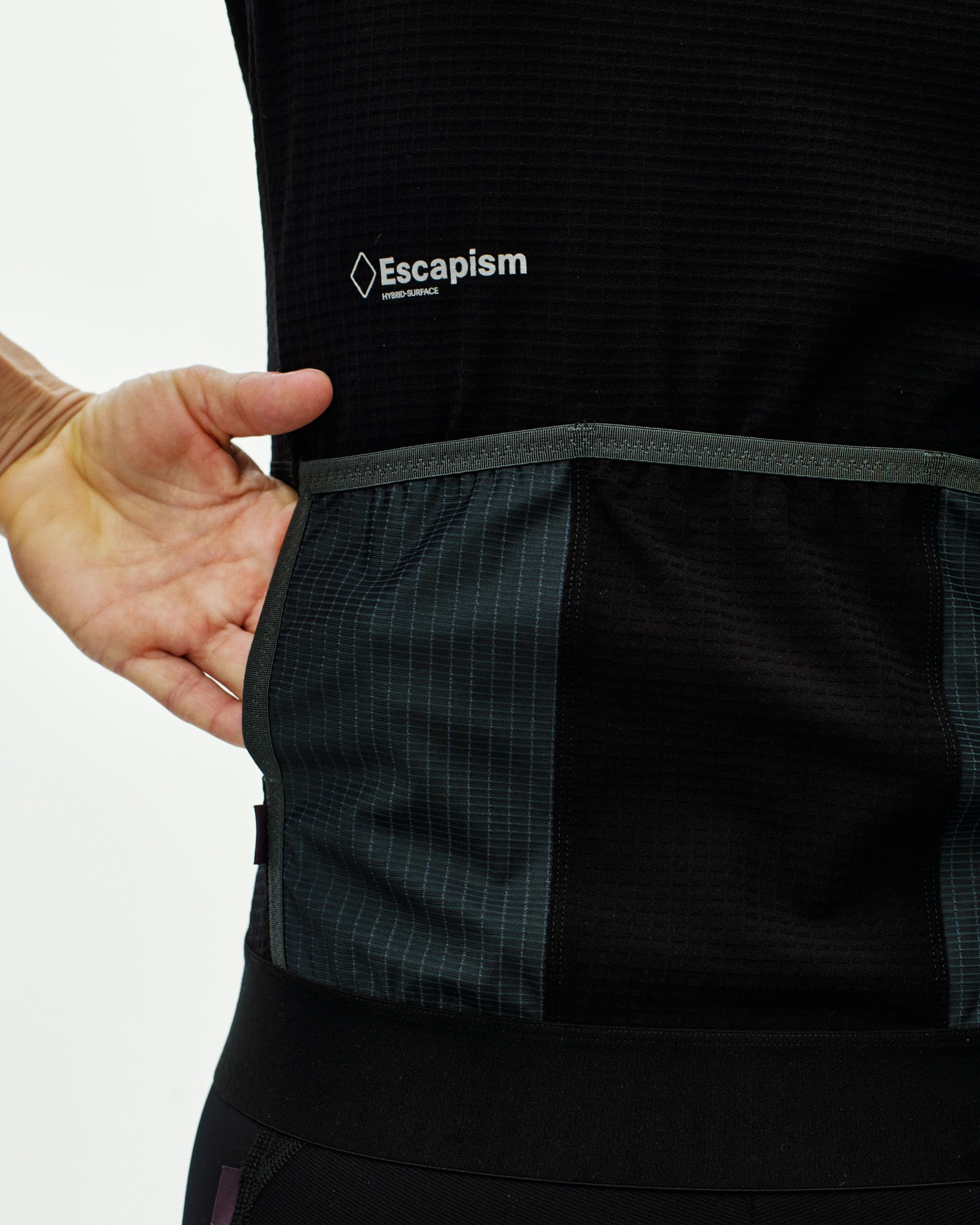 Black Escapism cycling jersey on model showing rear cargo pockets with ripstop fabric panels