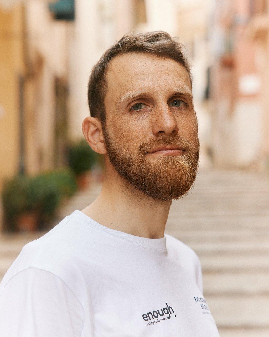 Model wearing Men's white t-shirt with text print on urban street