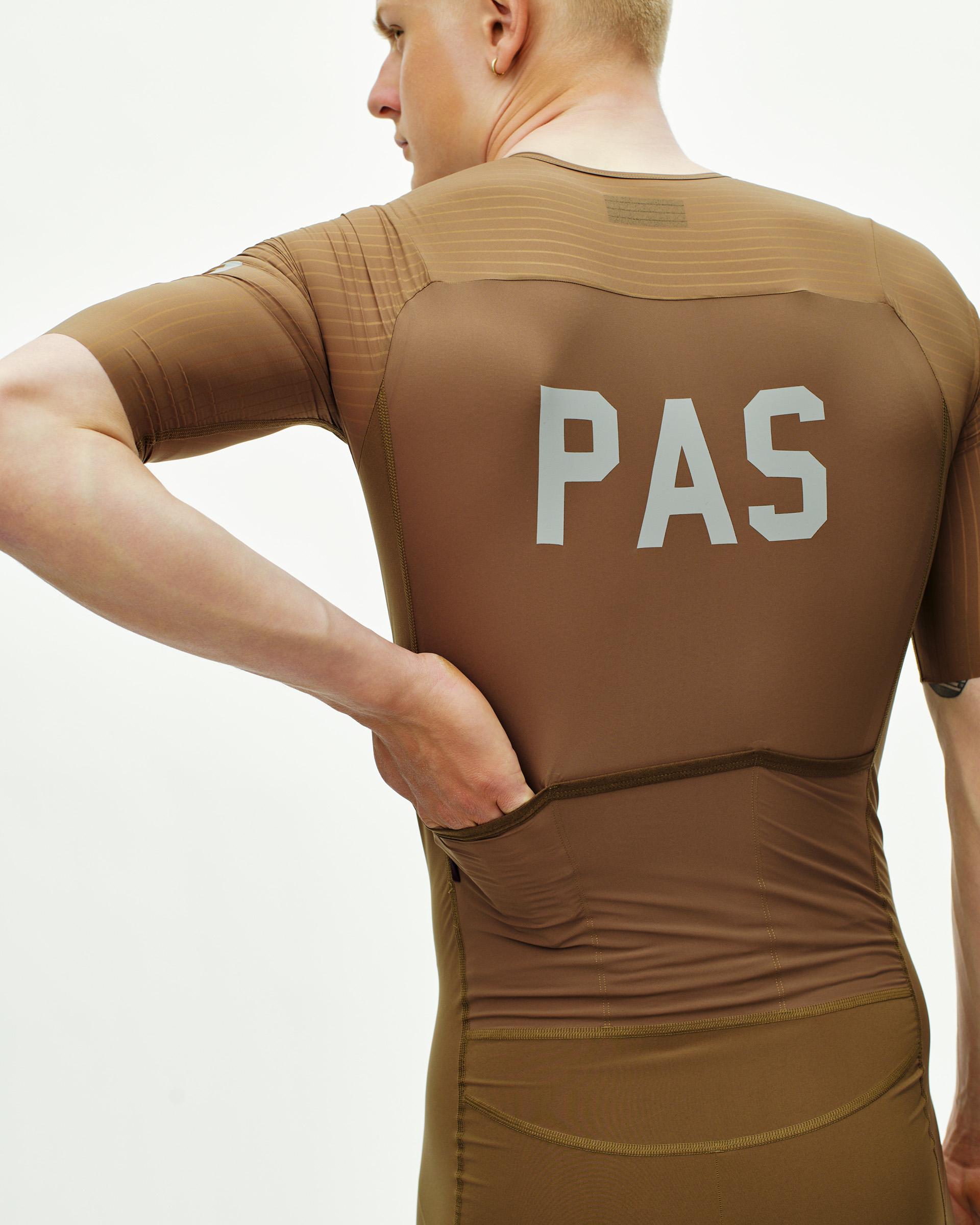 Brown PAS Mechanism Pro speedsuit on model, rear view with white chest logo