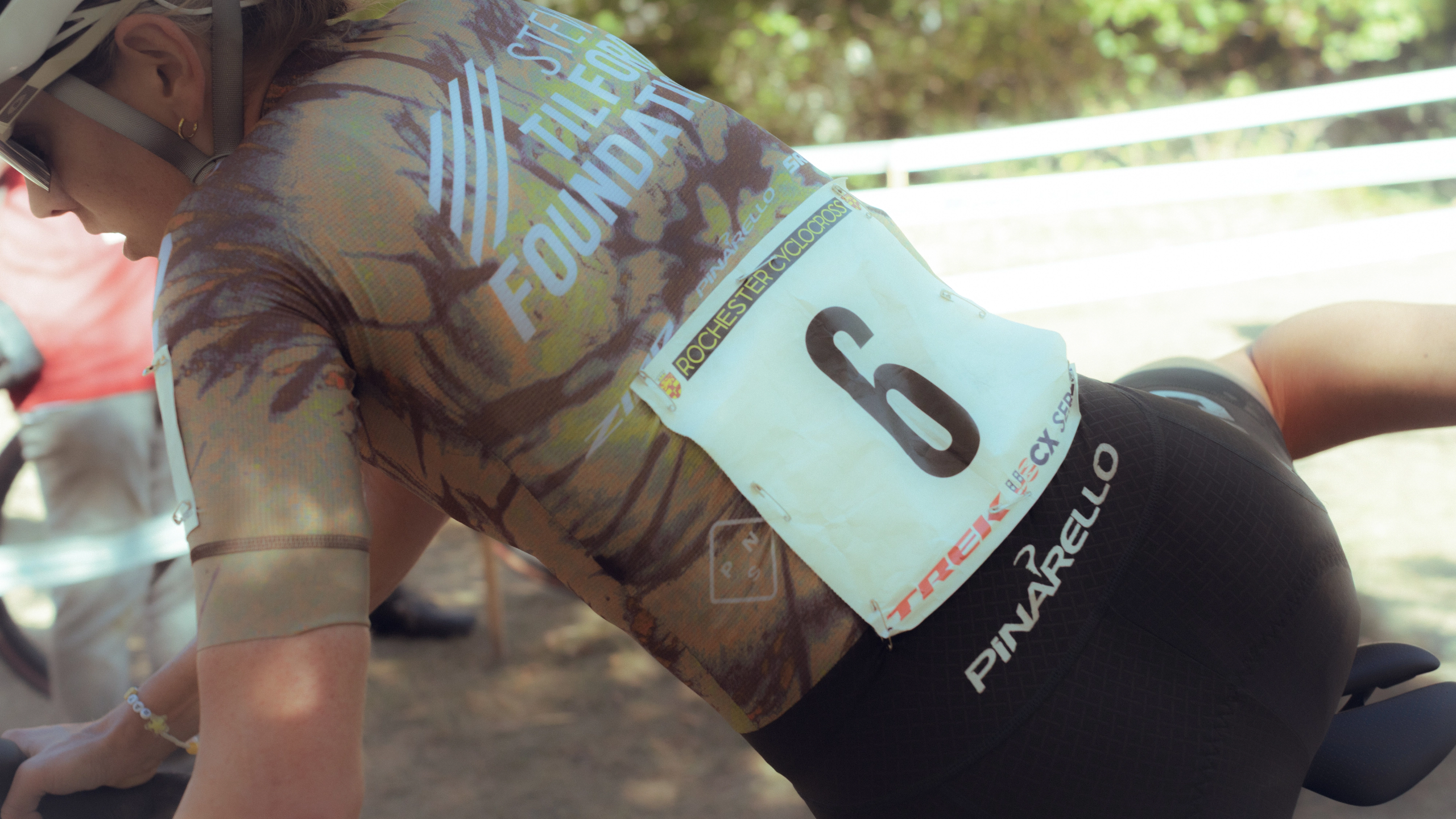 Black STFR Mechanism bibs on racing cyclist with race number and PINARELLO helmet