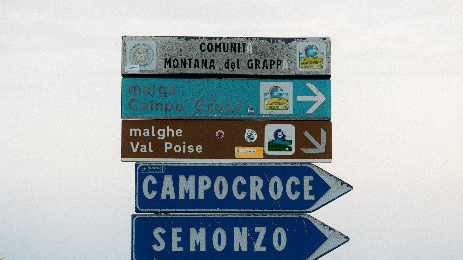 Road signs pointing to Italian cycling destinations including Campocroce and Semonzo
