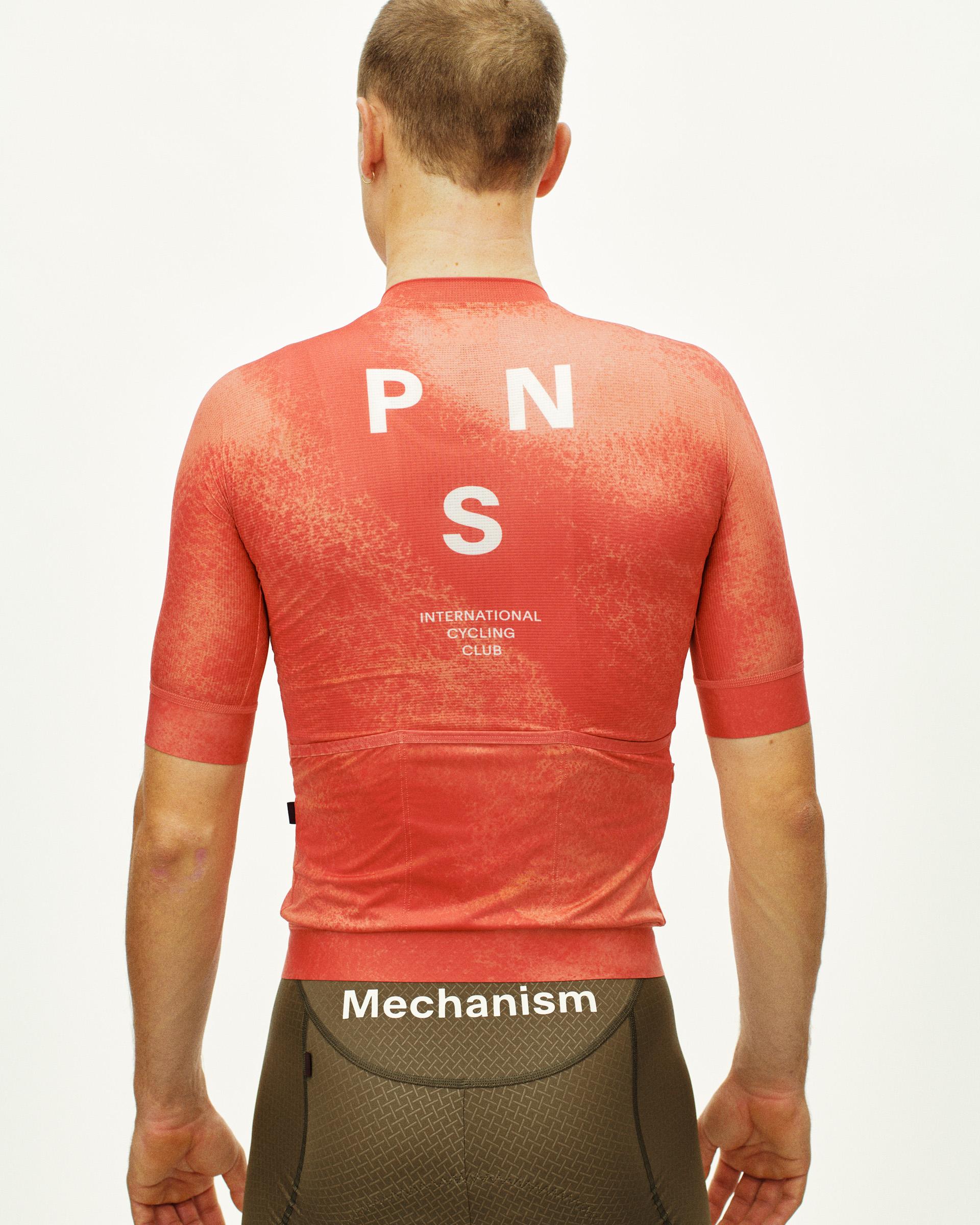 Orange Mechanism cycling jersey on model, rear view with white back print
