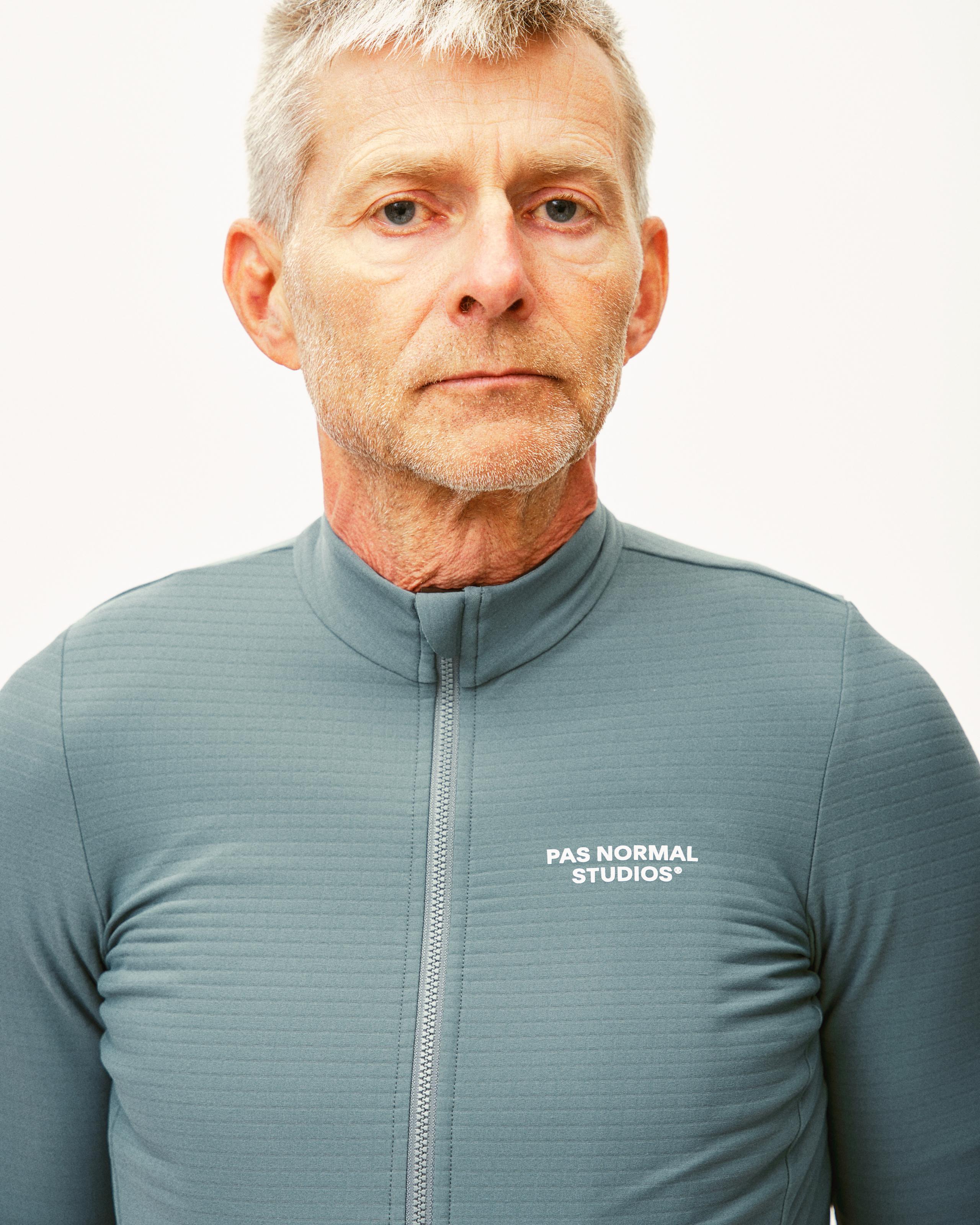Grey Teal Essential long sleeve cycling jersey on model with half zip and white chest logo