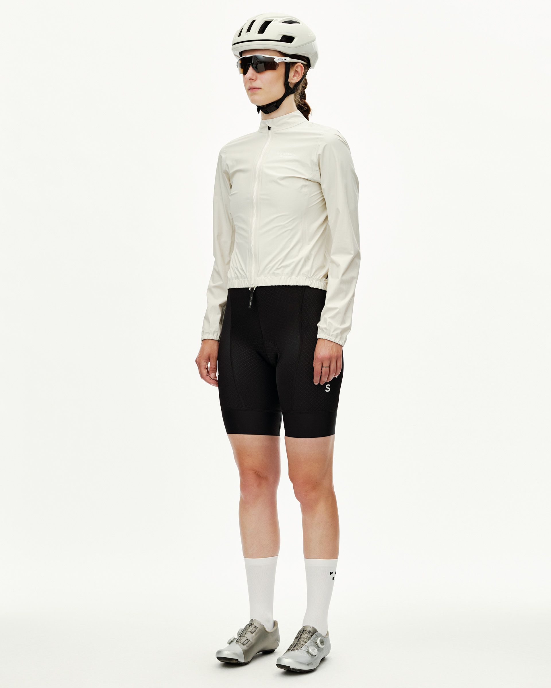 Off White Mechanism women's cycling rain jacket on model, three-quarter front view with elastic hem