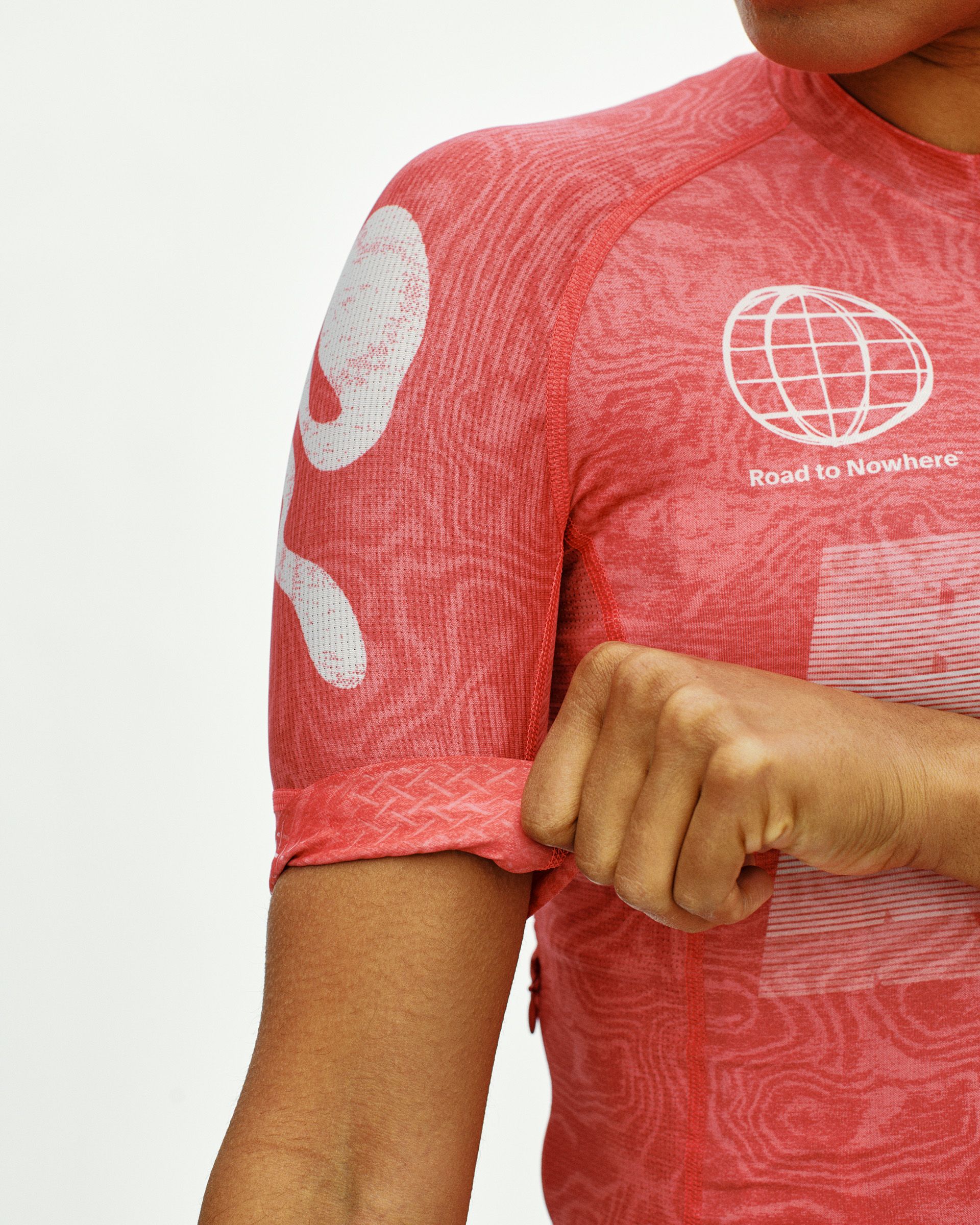 Red Mechanism cycling jersey on model, detail view of sleeve cuff and white Road to Nowhere globe chest print