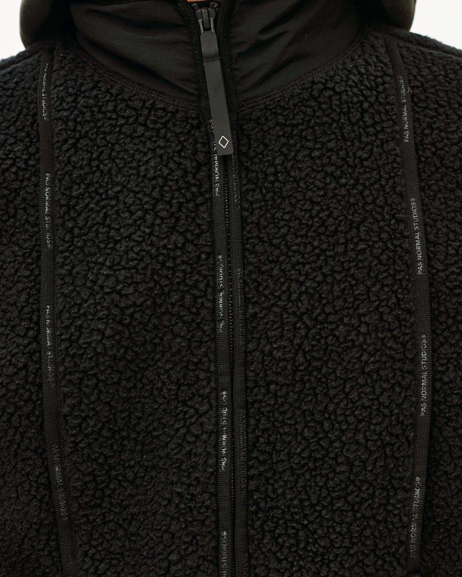 Black Off-Race Pile Fleece Vest, front detail view with branded zip tape and sherpa texture