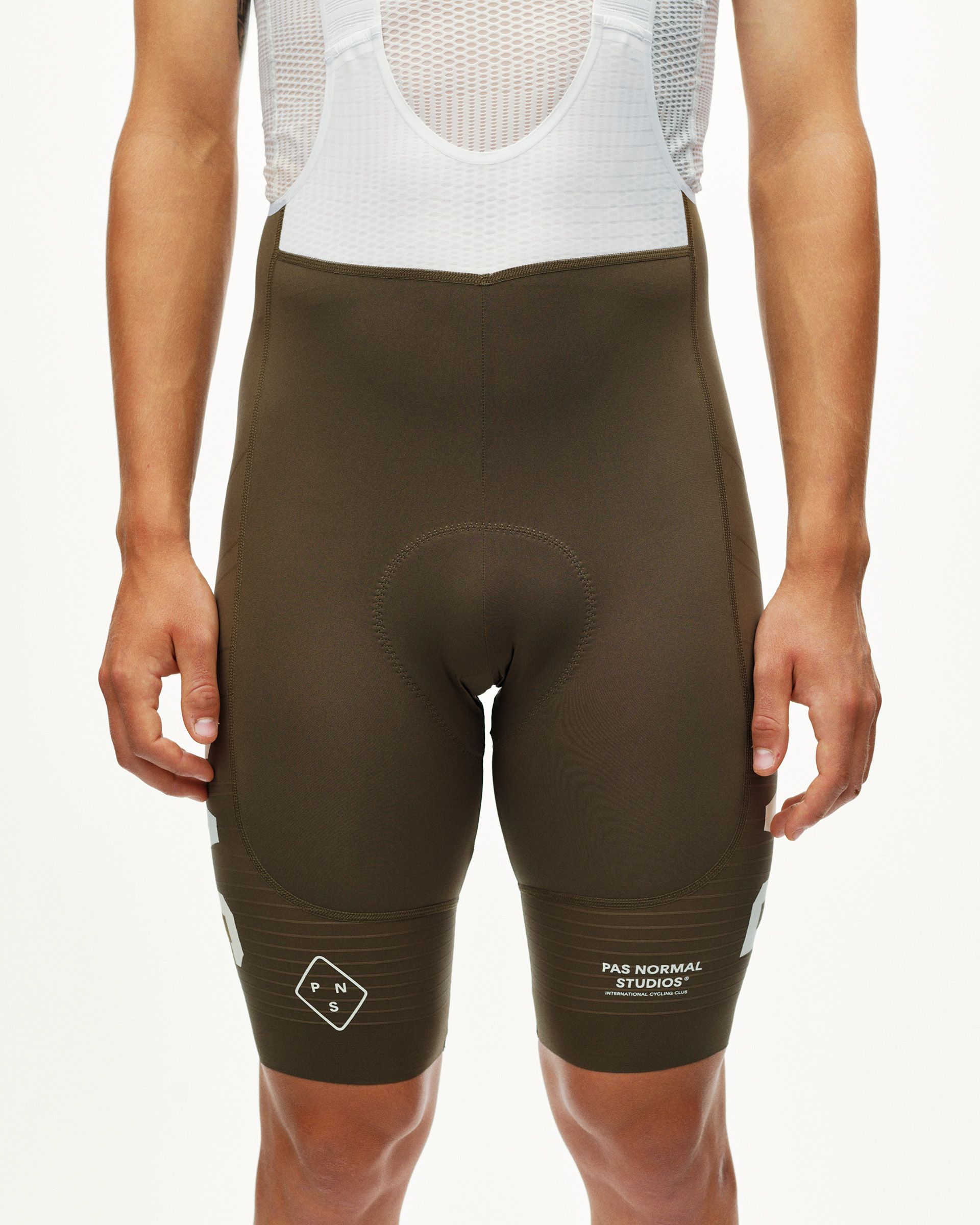 Dark Earth khaki PAS Mechanism Pro men's cycling bibs, front view on model with white leg print