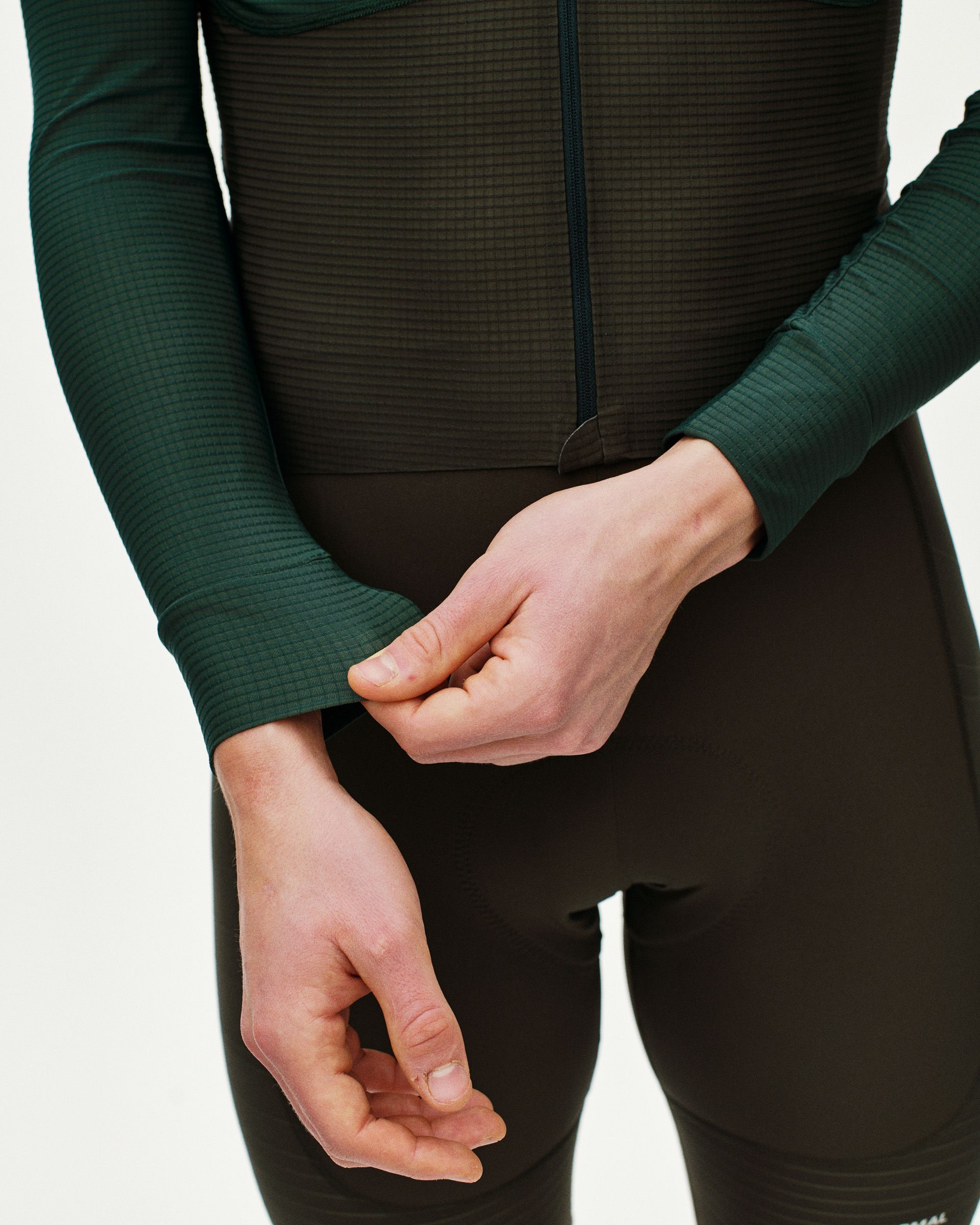 Green Mechanism Pro long sleeve cycling jersey on model showing ribbed cuffs and textured fabric