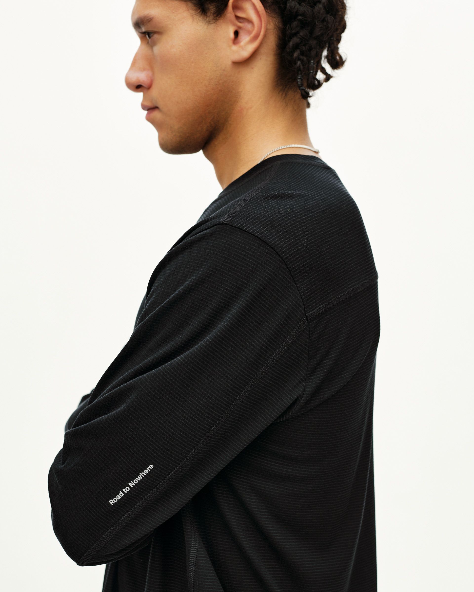 Black Balance Long Sleeve T-Shirt on model, side view with white sleeve text print