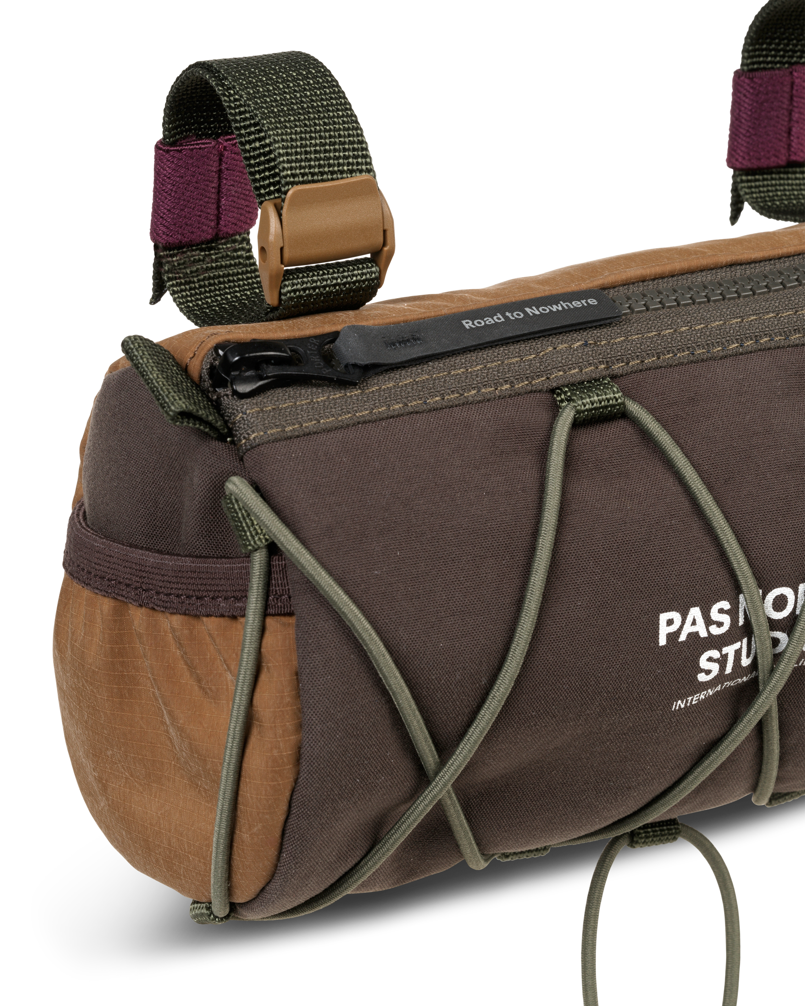 Light Brown Porter-Yoshida handlebar bag, detail view with olive bungee cord and contrast burgundy straps