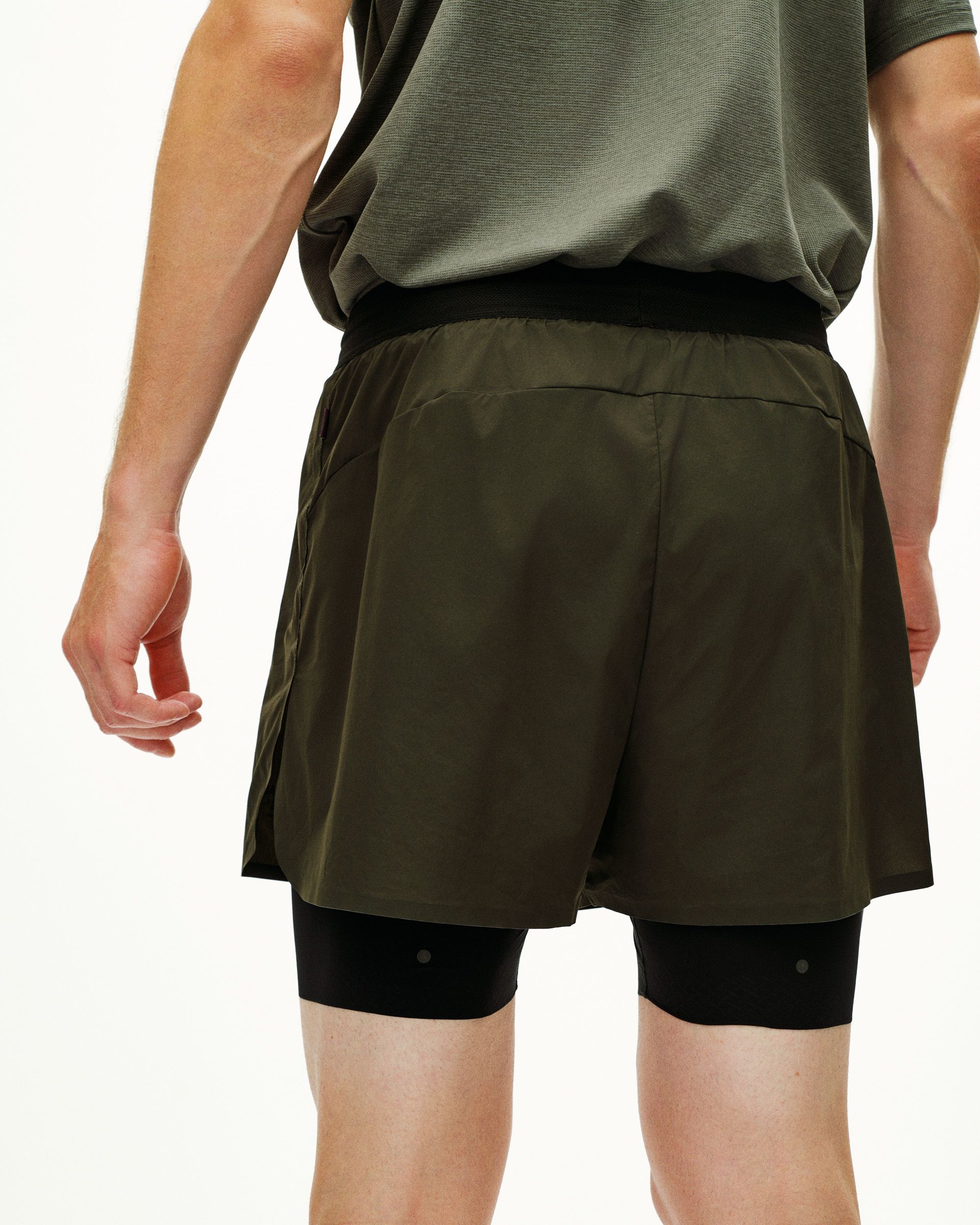 Dark Olive Balance 2-in-1 shorts on model, rear view with black compression liner