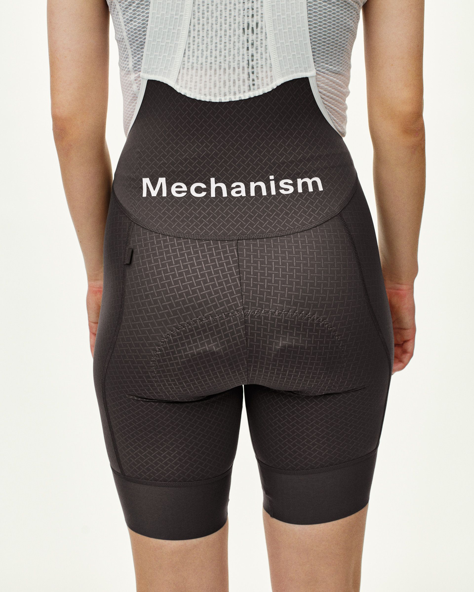 Dark Grey Mechanism cycling bibs, rear view on model with white logo print