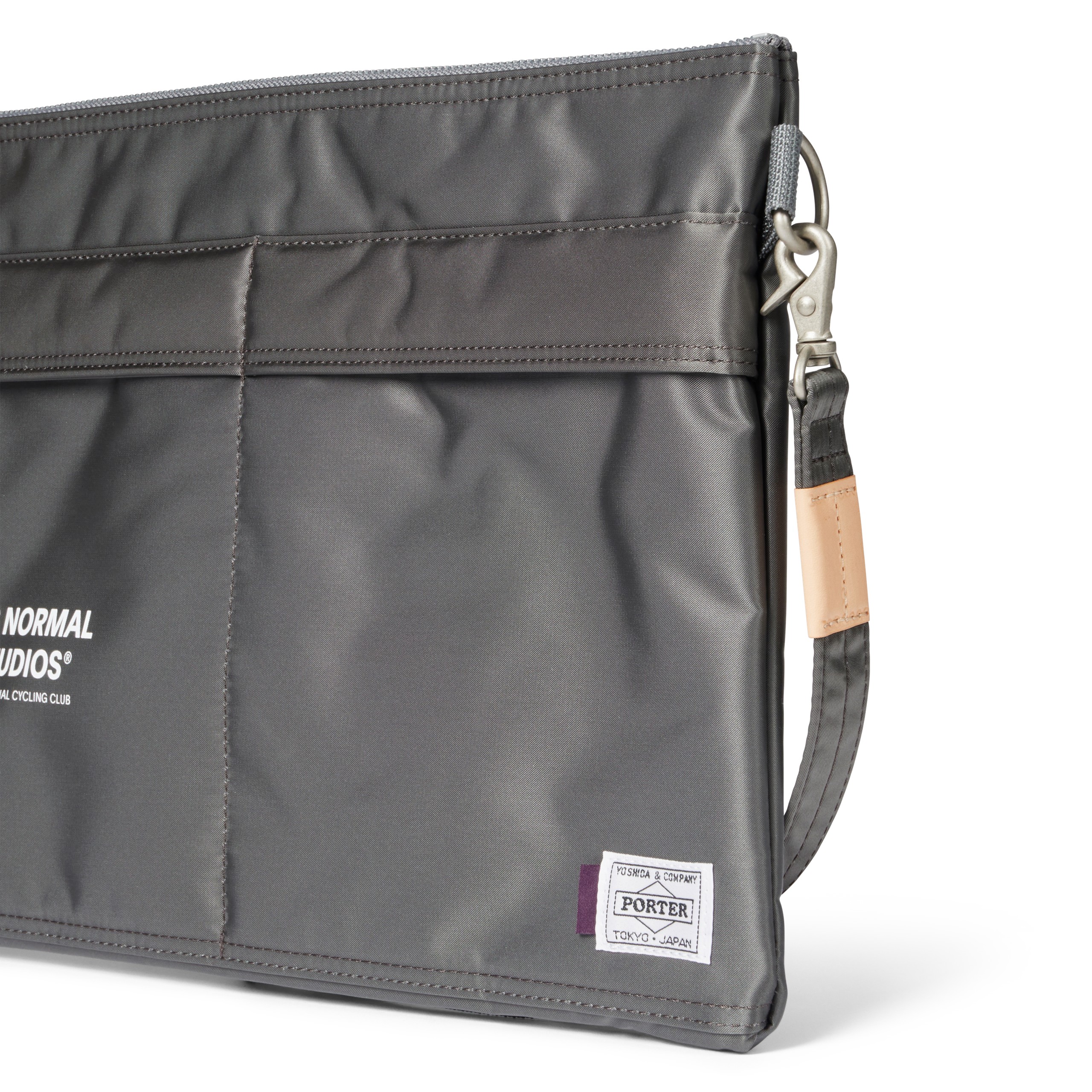 Grey Porter-Yoshida musette bag, three-quarter detail view with silver clip hardware and tan leather strap tab